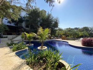 a swimming pool with palm trees in a resort at Los Lagos Resort Hotel in Capiatá