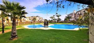 - une piscine dans une cour avec un palmier dans l'établissement AL-ANDALUS THALASSA, à Vera