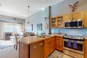 a kitchen with a sink and a living room at Copper Springs Lodge 430 in Copper Mountain