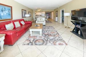 a living room with a red couch and a table at Emerald Isle in Pensacola Beach