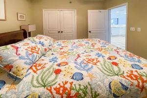 a bed with a colorful quilt on it in a bedroom at Emerald Isle in Pensacola Beach