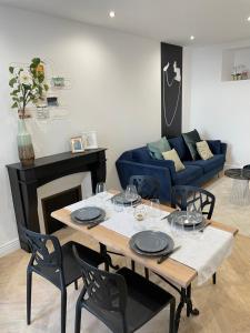 a living room with a table and a blue couch at L'Exception, sérénité et confort, Evian centre in Évian-les-Bains