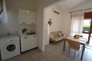 リニャーノ・サッビアドーロにあるLignano Comfortのキッチン、リビングルーム(洗濯機、テーブル付)