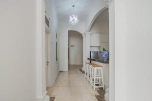 un corridoio con pareti bianche, tavolo e sedie di Capital O 90342 Kemang Garden a Giacarta