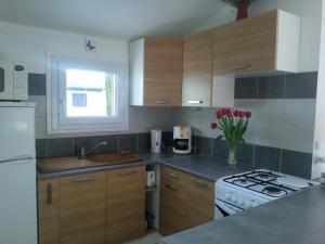 a kitchen with wooden cabinets and a white stove top oven at Stephanie Immobilier in Saintes-Maries-de-la-Mer