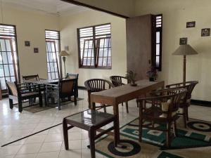 a living room with a table and chairs and windows at Hotel Garuda Syariah near Alun Alun Banjarnegara in Wonosobo