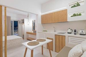 a kitchen with a bed and a table in a room at Vivere InBlue - Deluxe apartment over the sea in Pera Gyalos