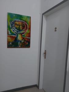 a painting hanging on a wall next to a door at Hospedaria A Italiana in Moura