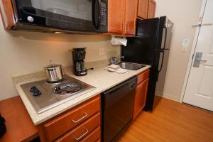 a small kitchen with a stove and a refrigerator at Candlewood Suites Boise - Towne Square, an IHG Hotel in Boise