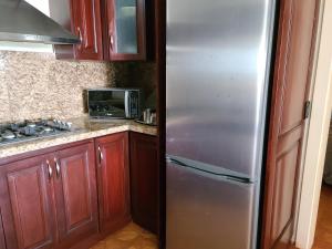 a stainless steel refrigerator in a kitchen with wooden cabinets at Villa Florencia in Boca Chica