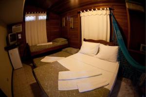 a bedroom with a hammock in a room at Complexo de Pousadas Caraguatá in Ilha do Mel