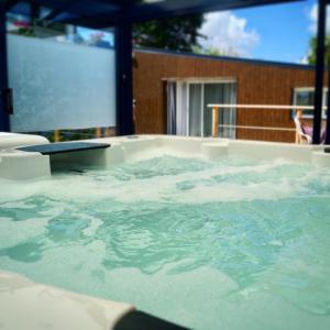 a bath tub filled with water next to a building at Maison d'hôtes du Carrec in Paimpol