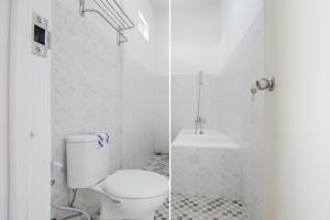 bagno bianco con servizi igienici e lavandino di Capital O 90342 Kemang Garden a Giacarta