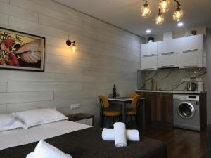a bedroom with a bed and a kitchen with a washing machine at New Gudauri, Loft 2 in Gudauri