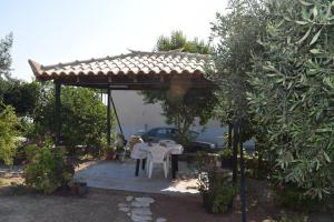 a pergola with a table and chairs in a garden at Villa Ioanna in Koroni