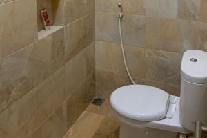 a bathroom with a white toilet in a room at RedDoorz Syariah near Kawasan Simpang Lima Pati in Pati