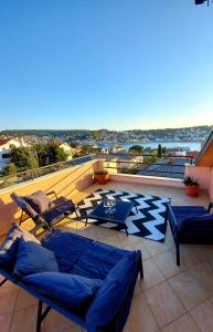 a patio with couches and tables on a balcony at Apartment Sun view in Mali Lošinj
