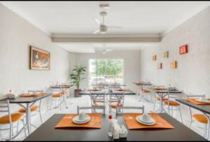 a dining room with tables and chairs and a window at Hotel Jardim do Cedro in Cedral