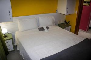 1 dormitorio con 1 cama con arco en Residence Victoria Brasil, en Natal
