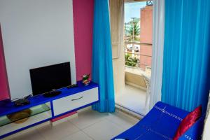 a living room with a tv and a blue chair at Residence Victoria Brasil in Natal