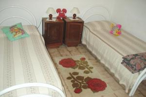 1 dormitorio con 2 camas y 2 sillas en Casa a 300mt.dal mare CalaSinzias, 6 letti, AC, Pets welcome, Wi-Fi free, en Villasimius