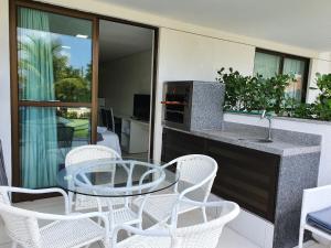 a patio with a table and chairs and a kitchen at Laguna Beach Porto in Porto De Galinhas