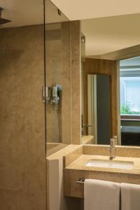 een badkamer met een wastafel en een glazen douche bij One Ciudad de Mexico La Raza in Mexico-Stad