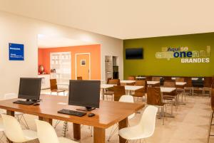 a room with tables and chairs with two computers on them at One Ciudad de Mexico La Raza in Mexico City