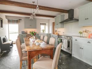 a kitchen with a wooden table and chairs at Crane Field Laithe in Airton