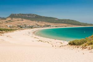 a beach with a group of people in the water at Apartamento Triana l Bolonia, Tarifa in Bolonia