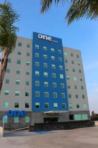 um edifício dmg com um sinal na lateral em One Guadalajara Tapatio em Guadalajara