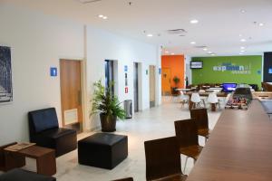 a lobby of an office with a table and chairs at One Guadalajara Tapatio in Guadalajara