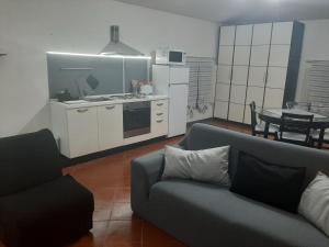 a living room with a couch and a kitchen at B&B Principe Calaf 3 in Lucca