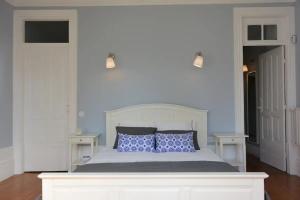 a bedroom with a white bed with blue pillows at Bonjardim 466 - Historic Townhouse in Porto