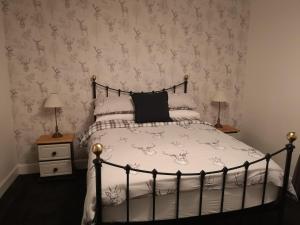 a bedroom with a bed with a black and white comforter at The Cambus Flat Cambuskenneth Stirling in Stirling