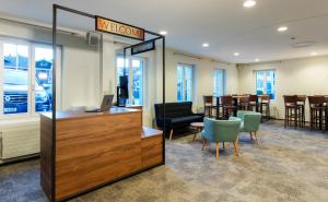 a lobby with a reception desk and chairs and tables at Hotel Kreuz by b-smart in Sachseln