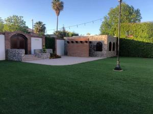 a house with a yard with a green lawn at Hotel Andares de Kino by Rotamundos in Magdalena de Kino