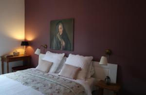 a bedroom with a bed with a painting on the wall at "Le Vent d'Étoile" B&B and Guesthouses in Mormoiron