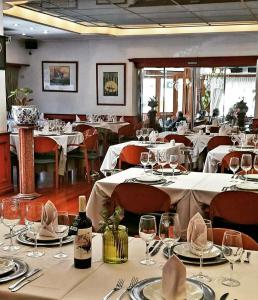 哥多華的住宿－HOTEL CASTELAR CORDOBA，用餐室配有白色桌椅和酒杯