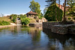 Un río con un banco a un lado. en Meždzirnas Country House & SPA, en Kabile