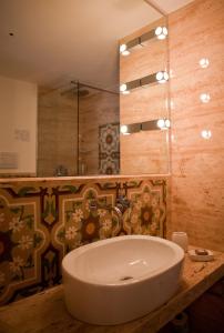 a bathroom with a tub, sink, and mirror at Aegusa Hotel in Favignana