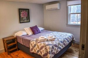 een slaapkamer met een bed met twee handdoeken erop bij Brook Road Inn in Goshen