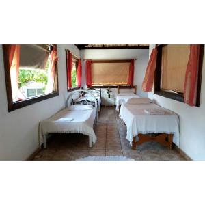a group of beds in a room with windows at HOSTEL Bom Gosto in Canavieiras