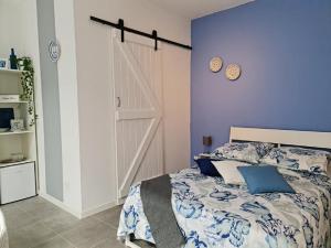 a bedroom with a bed and a blue wall at Deluxe B&B "Casa Alegria", Tarrafal in Tarrafal