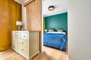 1 dormitorio con cama y pared azul en Apartament Księżycowy, en Olsztyn