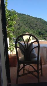 uma cadeira sentada num alpendre com vista para a praia em B&B Lacrêma em Finale Ligure