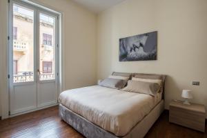 ein Schlafzimmer mit einem Bett und einem großen Fenster in der Unterkunft Anna's Luxury Apartment in Palermo