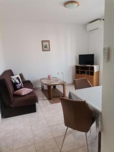 ein Wohnzimmer mit einem Sofa und einem Tisch in der Unterkunft Apartments Petrica in Malinska