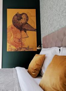 Un oiseau est assis sur un mur à côté d'un lit dans l'établissement B&B De Stadssingel, à Steenwijk