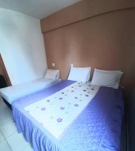 a bedroom with two beds with blue and white sheets at Flats Bueno em Goiânia in Goiânia